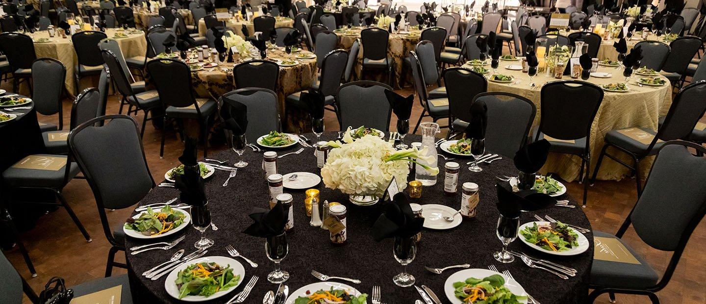 empty banquet room with salads at place settings